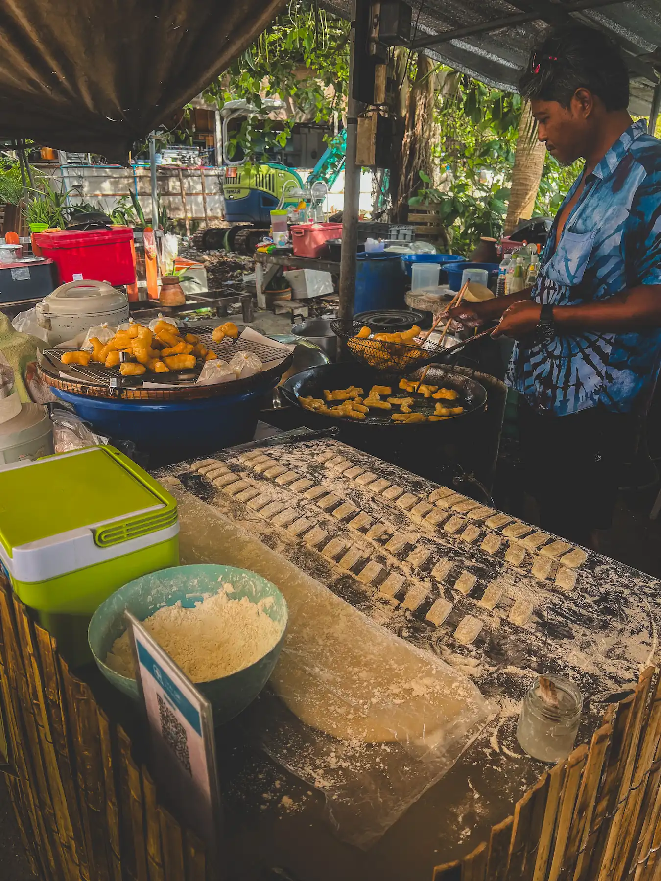 Local man making fried dough in an outdoor cooking area