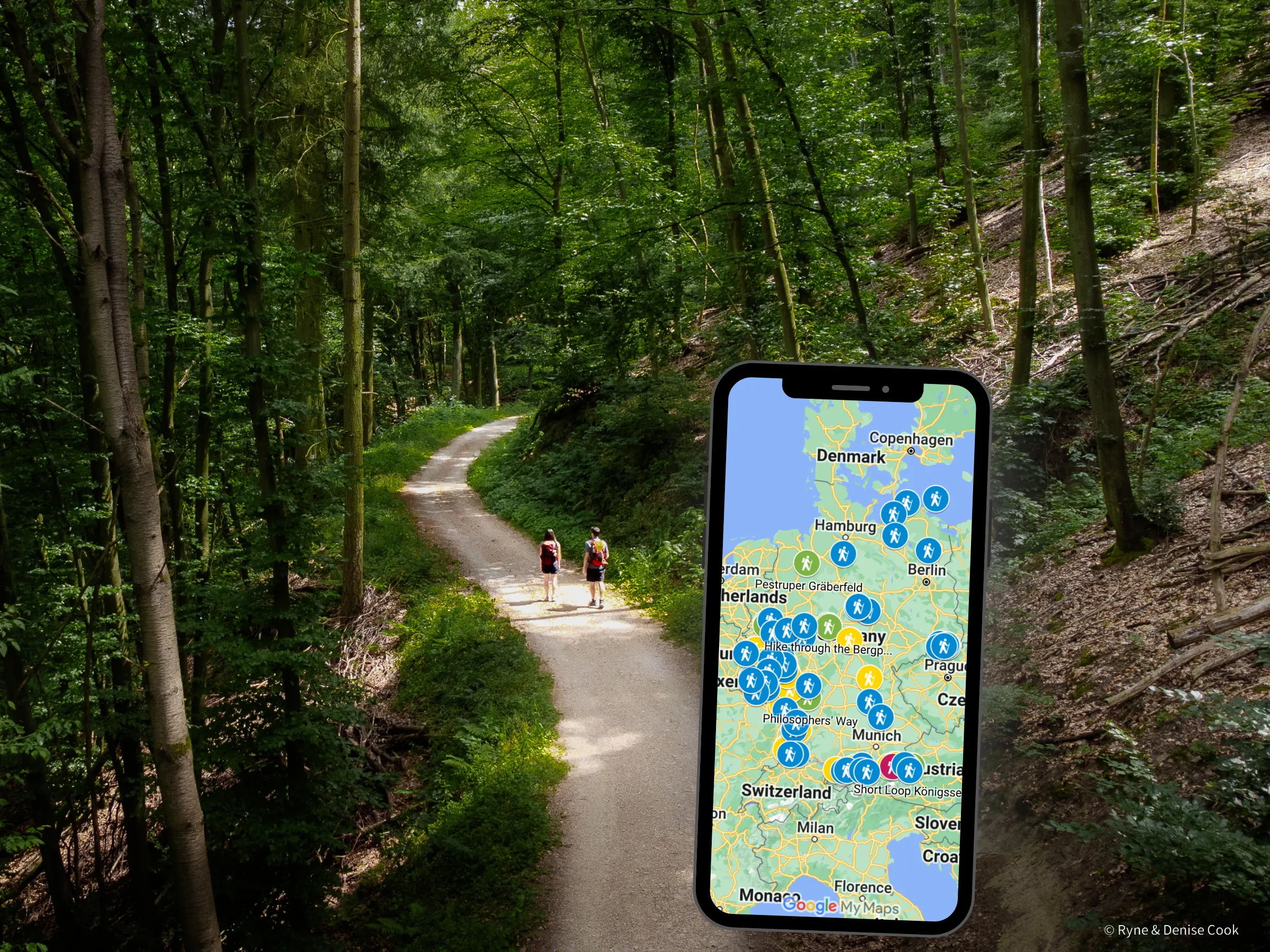 Couple hikes on a trail in the forest. Phone with custom map open in foreground.