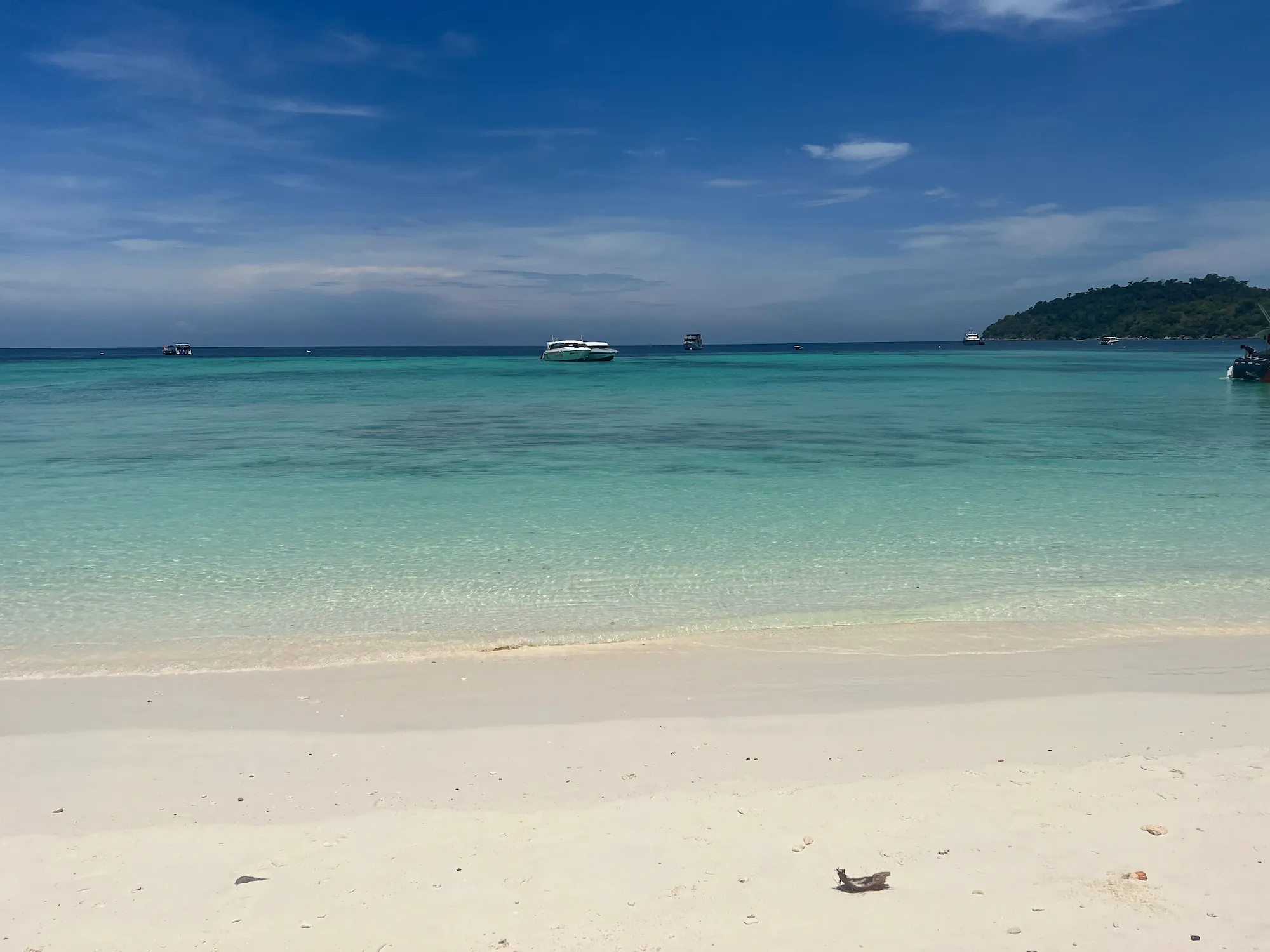 Beach with clear blue water and small boat