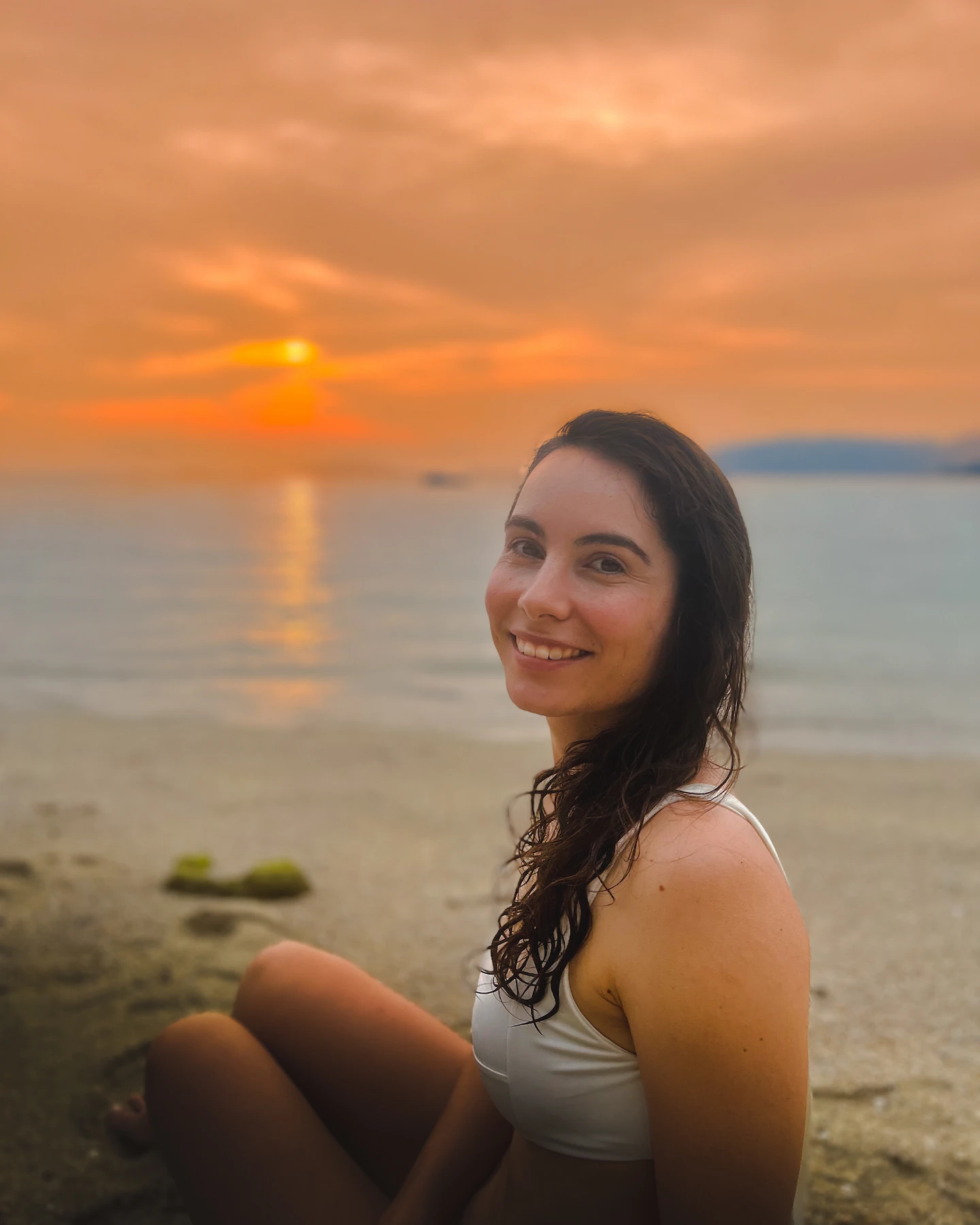 Woman smiling at beach during sunset
