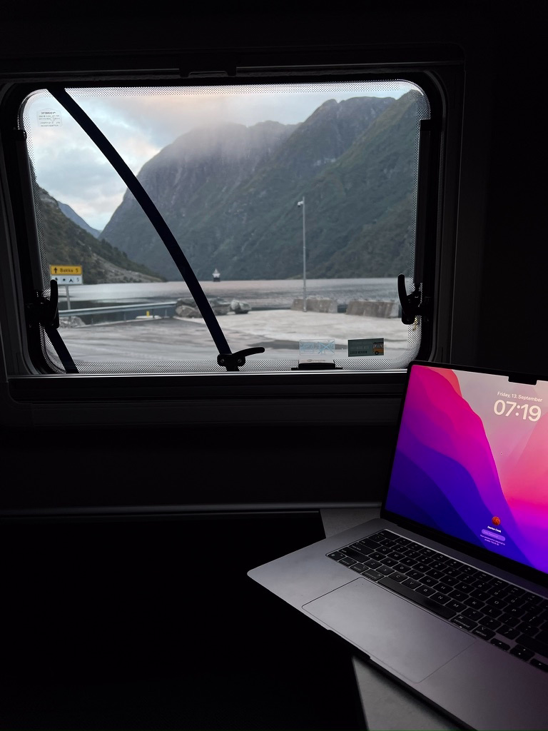 Laptop in front of window overlooking Norwegian fjord